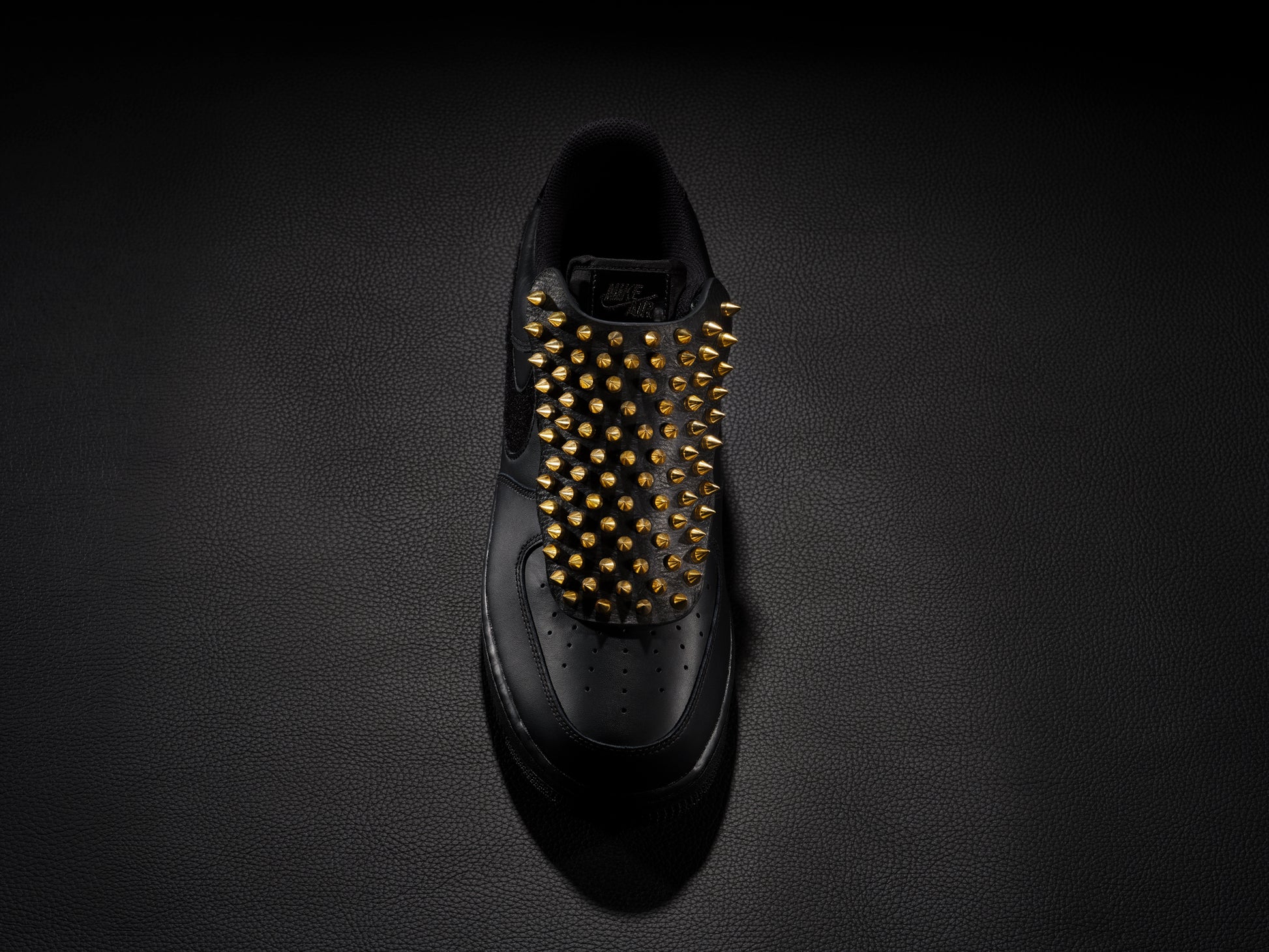 Black sneaker with gold spike overlay for edgy custom style.
