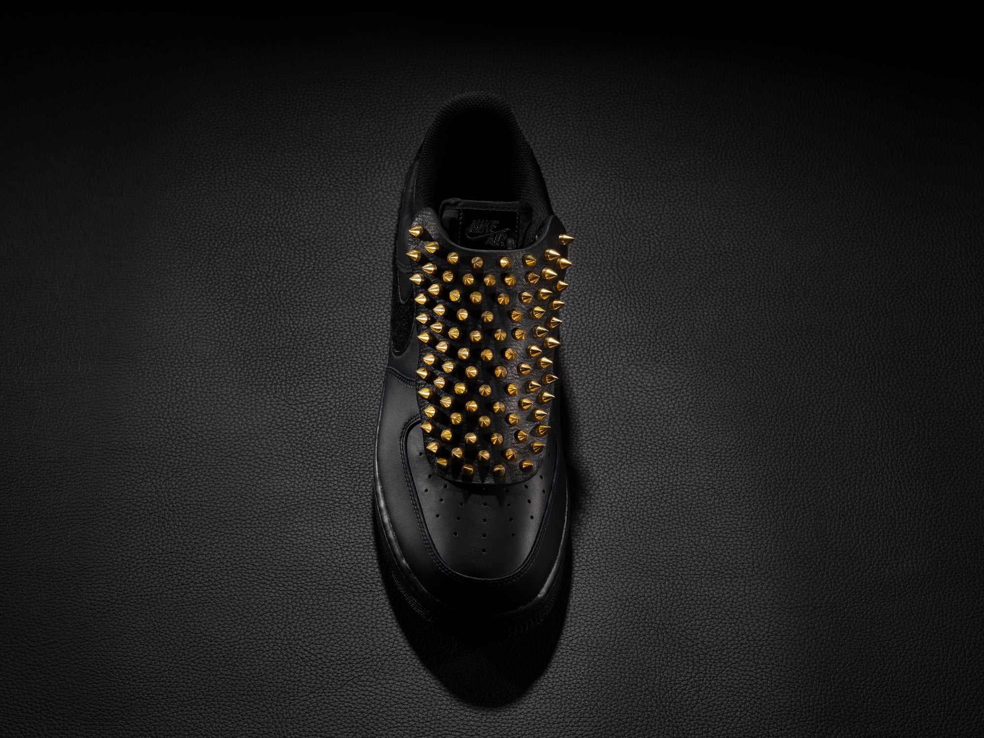 Black sneaker with gold spike overlay for edgy custom style.