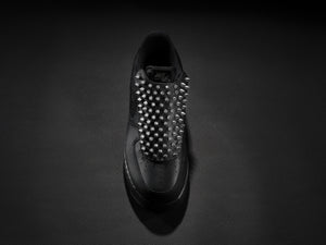 Black sneaker with silver spike overlay for edgy custom style.